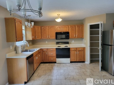 A kitchen with wooden cabinets and a tile floor.
