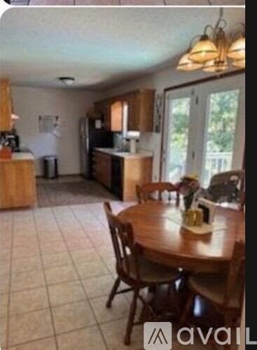 A kitchen with a table and chairs in the foreground.