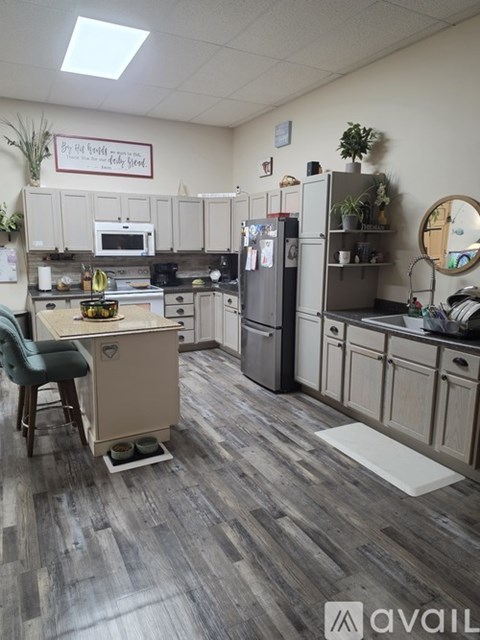 A kitchen with a table and chairs and a fridge.