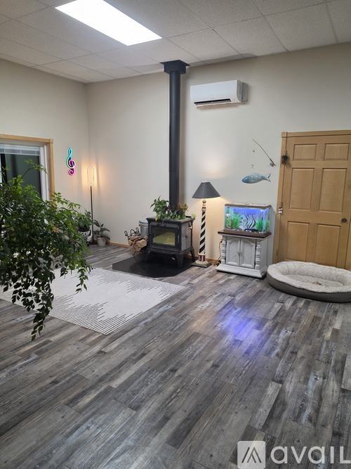 A room with a wood stove and a fish decoration on the wall.
