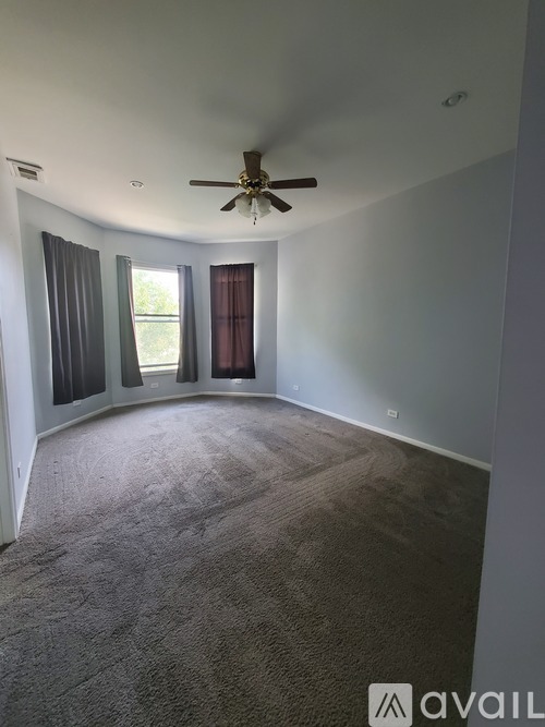 A living room with a couch, coffee table, and ceiling fan.