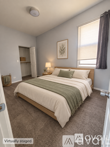 A bedroom with a bed, lamp, and picture on the wall.