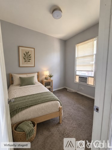 A bedroom with a bed, nightstands, and a window.