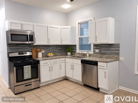 A kitchen with white cabinets and a stainless steel dishwasher.