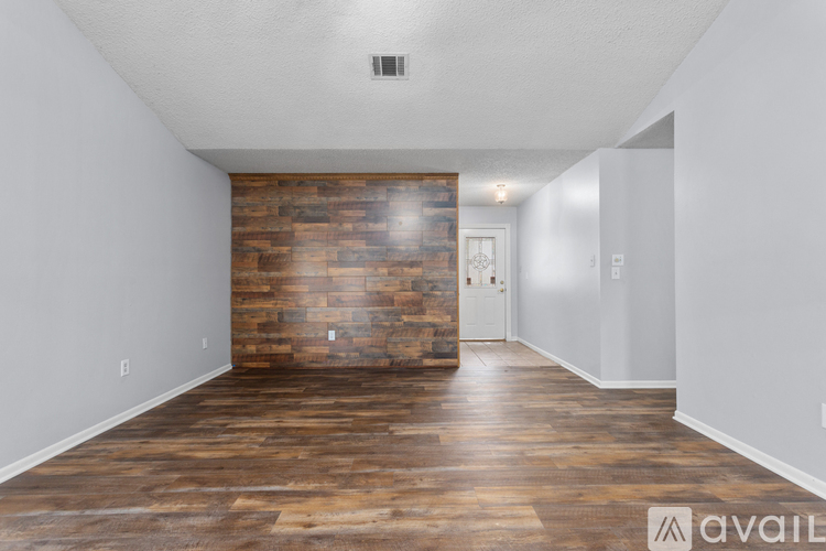 A room with wooden flooring and a brick wall.