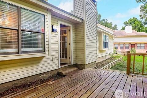A house with a wooden deck and a glass door.