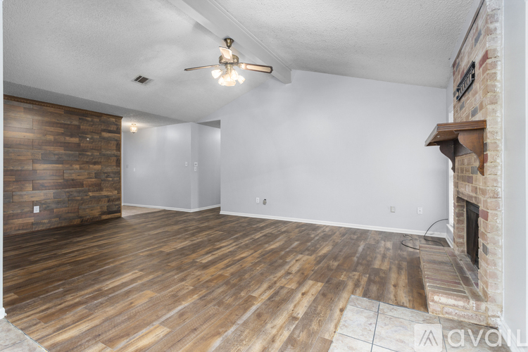 A room with wooden flooring and a fireplace.