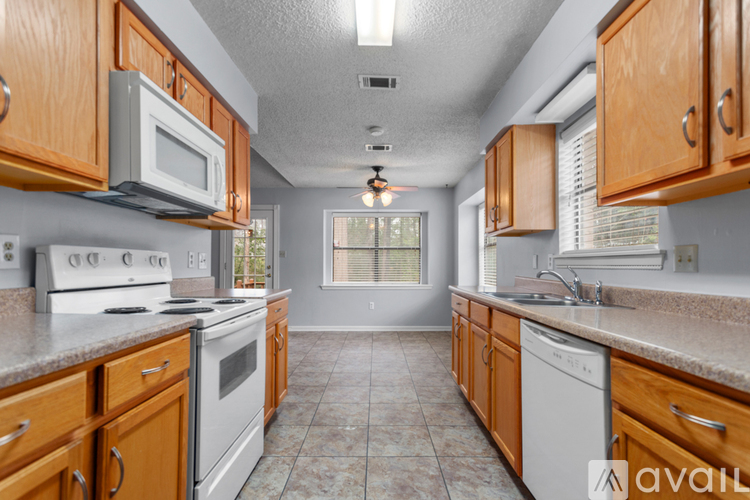 A kitchen with wooden cabinets and a white stove top oven.
