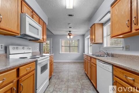 A kitchen with wooden cabinets and a white stove top oven.
