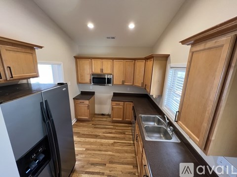 A kitchen with wooden cabinets and a black countertop.
