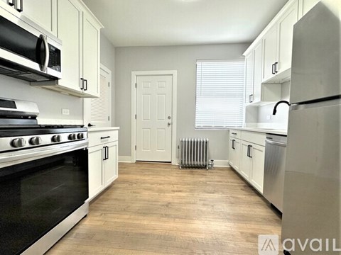 A kitchen with white cabinets and a black stove top oven.
