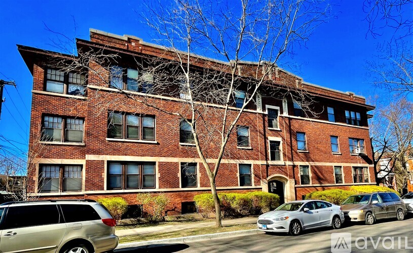 A red brick building with a tree in front of it.
