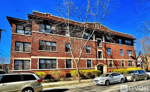 A red brick building with a tree in front of it.
