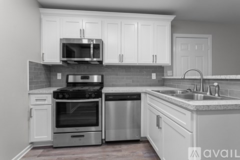 A kitchen with white cabinets and stainless steel appliances.