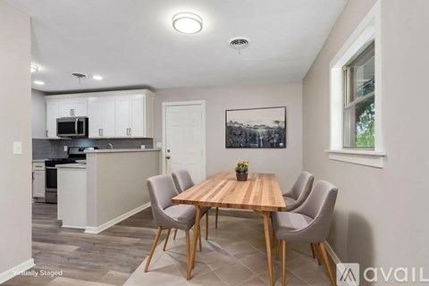 A dining room with a wooden table and chairs.