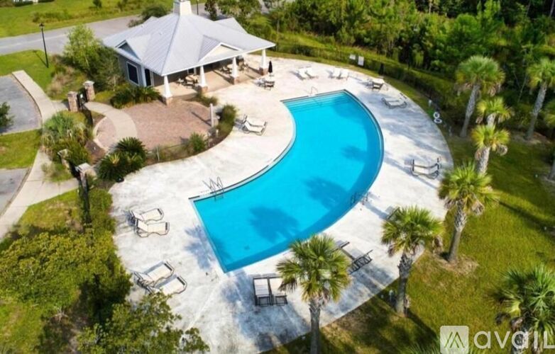 A pool surrounded by palm trees and a house.