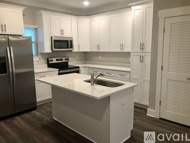 A modern kitchen with white cabinets and a central island.