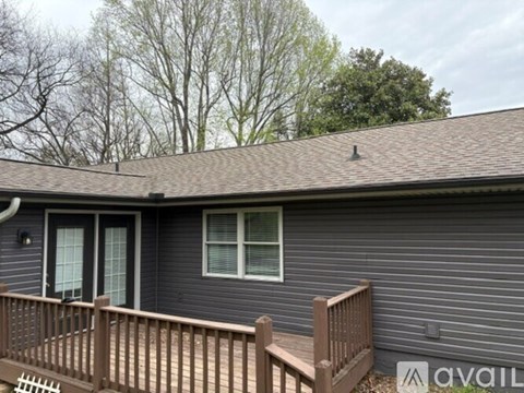 A house with a brown fence and a grey roof.