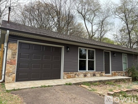 A two-car garage with a stone pillar on the left side.