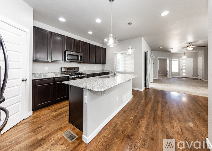 A kitchen with dark brown cabinets and a white island.