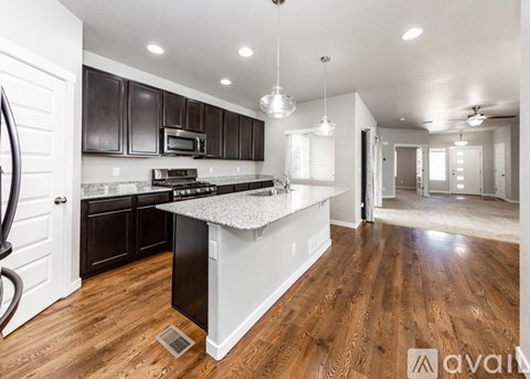 A kitchen with dark brown cabinets and a white island.