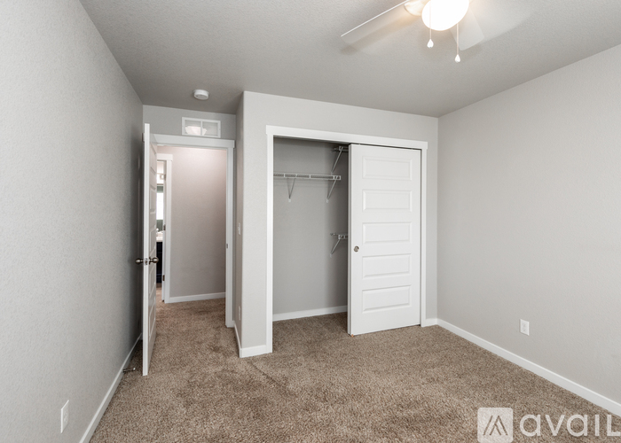 A bedroom with a carpeted floor and a white door.