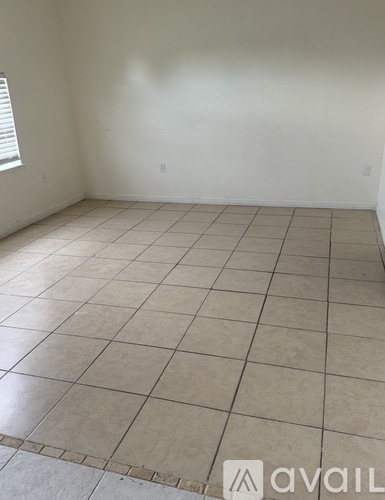 A room with a tiled floor and a window.