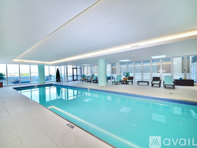 A large indoor swimming pool with a person in the background.
