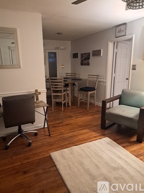 A living room with a couch, chairs, and a dining table.