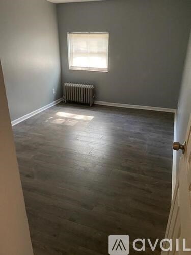 A room with a window and a radiator on the floor.