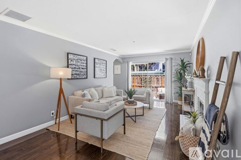 A living room with a grey couch and a wooden floor.