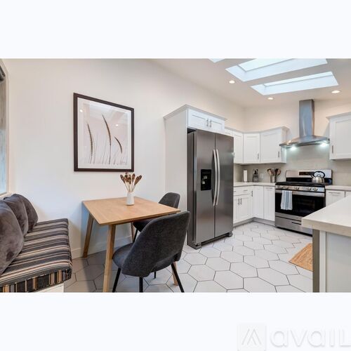 A kitchen with a table and chairs and a fridge.