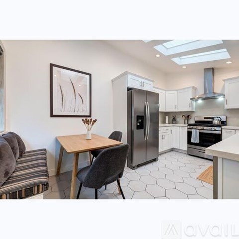 A kitchen with a table and chairs and a fridge.