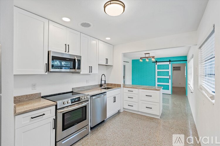 A kitchen with white cabinets and a black stove top oven.