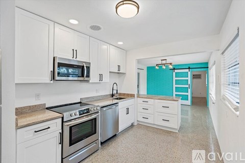 A kitchen with white cabinets and a black stove top oven.