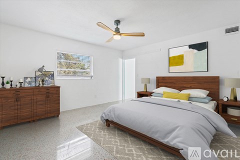 A bedroom with a bed, dresser, and ceiling fan.