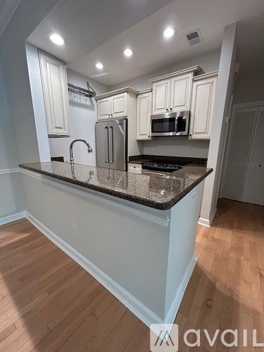 A kitchen with white cabinets and a granite countertop.