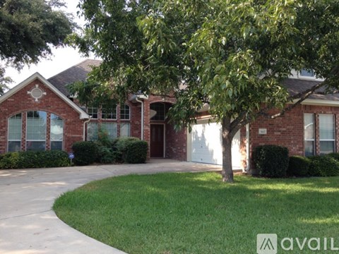 A brick house with a tree in front.