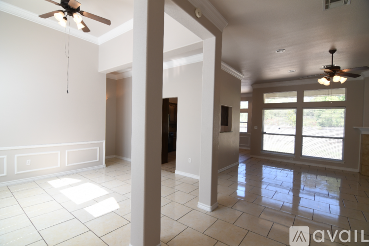 A spacious room with a ceiling fan and tiled flooring.