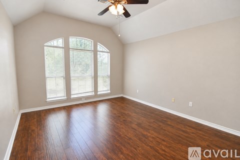 A spacious room with a ceiling fan and tiled flooring.