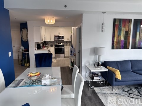 A modern kitchen with blue accent chairs and a white dining table.