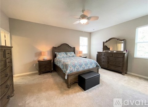 A bedroom with a bed, dresser, and mirror.