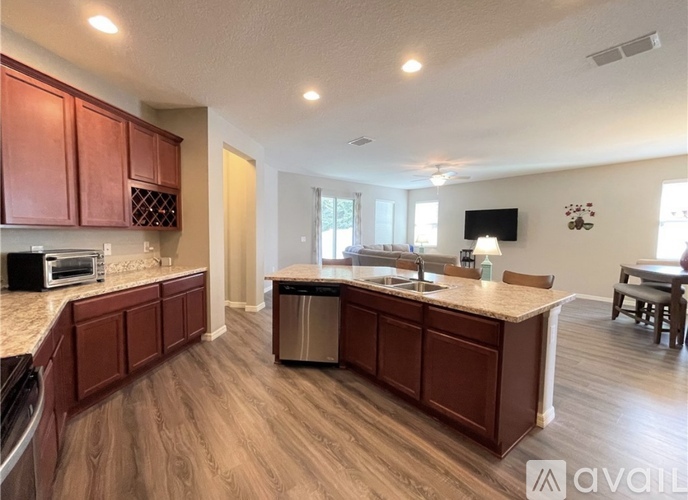 A kitchen with brown cabinets and a granite countertop.