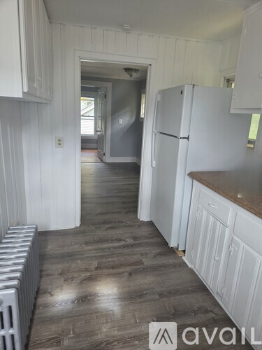 A kitchen with white cabinets and a white fridge.