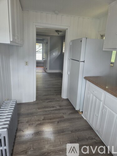 A kitchen with white cabinets and a white fridge.