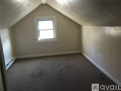 A room with a window and carpeted floor.