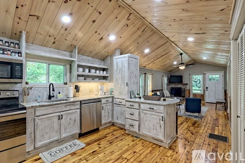 A kitchen with wooden cabinets and a wooden ceiling.