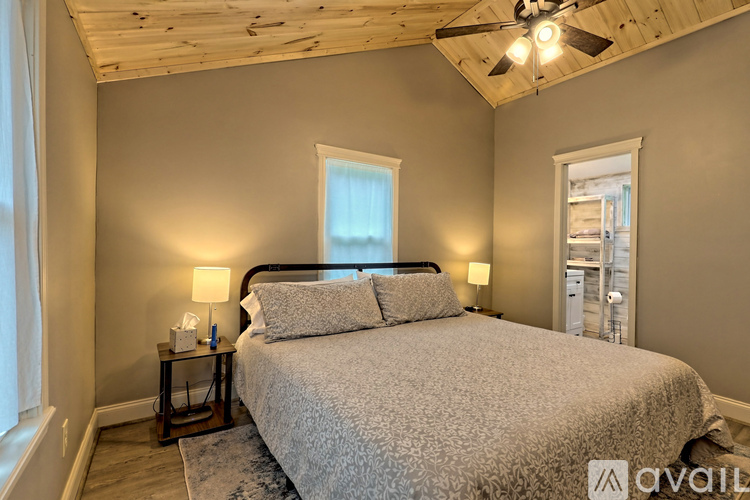 A bedroom with a large bed and a ceiling fan.