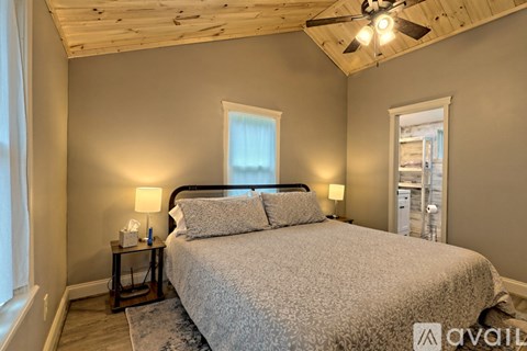 A bedroom with a large bed and a ceiling fan.