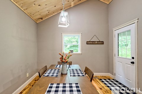 A dining room with a wooden table and chairs.